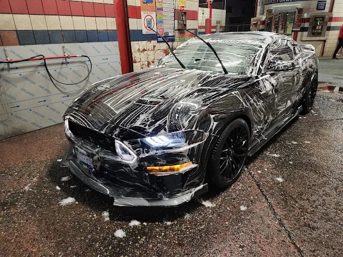 Black Ford Mustang covered in wash foam