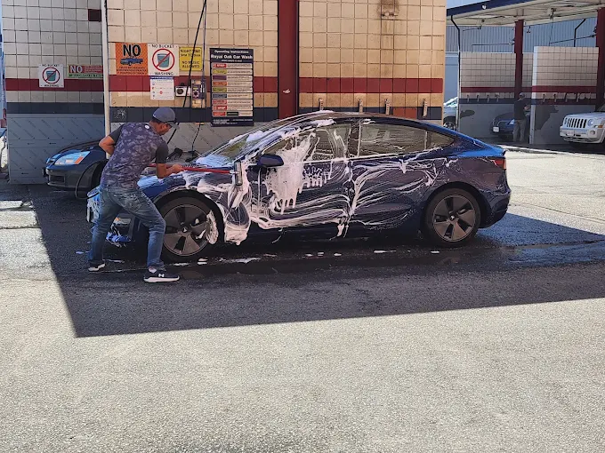 Customer washing a Tesla in a self-service bay
